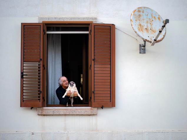 Jeden muž a jeden pes zo Sardíne. Pán vyložil z okna domáceho maznáčika, aby pozdravil paničku v dave pútnikov, ktorí kráčali pod oknami.