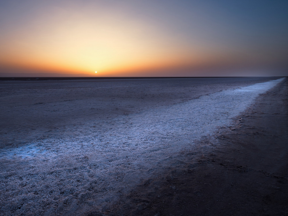 Východ slnka nad soľným jazerom El Jered v Tunisku