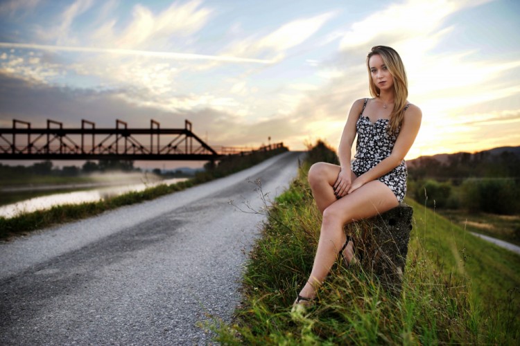 Dievča pri železnom moste v podvečer