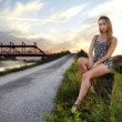 Dievča pri železnom moste v podvečer