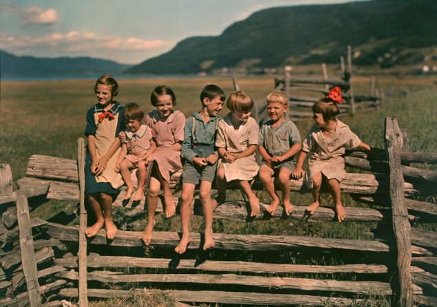 Seven siblings sit on a wooden fence in Quebec, Canada, May 1939. PHOTOGRAPH BY HOWELL WALKER, NATIONAL GEOGRAPHIC