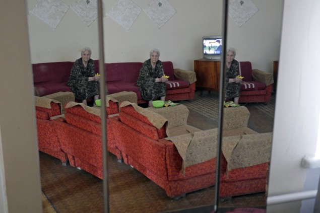 Žena v odraze zrkadiel  na chodbe krízovej ubytovne Duša Donbasu.