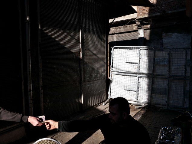 Muž platí chlapcovi, ktorý mu doniesol jedlo z reštaurácie, pred policajnou zábranou v Diyarbakire.